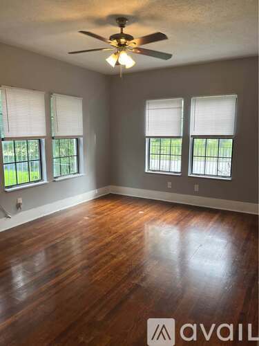 A room with wooden floors and a ceiling fan.