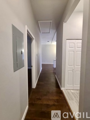 A hallway with a white door on the right and a grey door on the left.