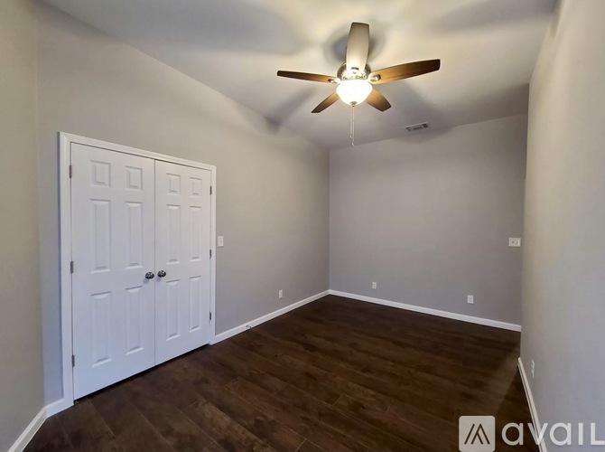 A room with a ceiling fan and a white door.