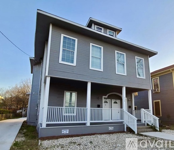 A two-story house with a grey exterior and white trim.
