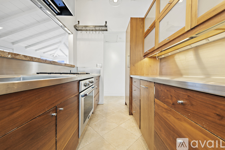 A kitchen with wooden cabinets and a stainless steel sink.