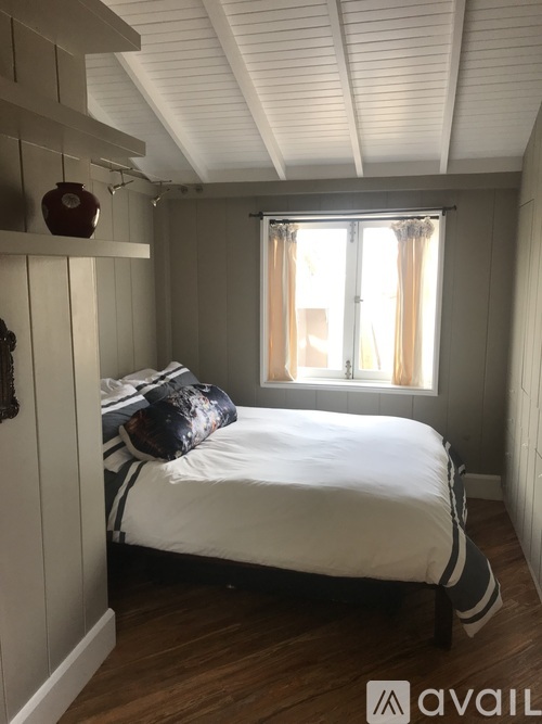 A bedroom with a bed, pillow, and a window.