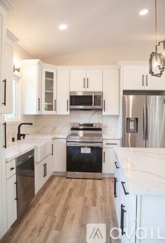 A kitchen with white cabinets and a black stove top oven.