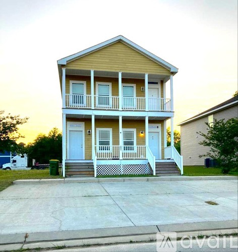 A two-story house with a balcony and a front porch.