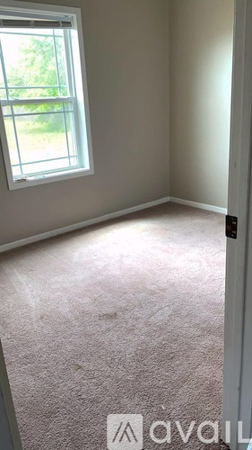 A room with a window and carpeted floor.