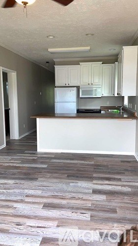 A kitchen with a white counter and a stainless steel refrigerator.
