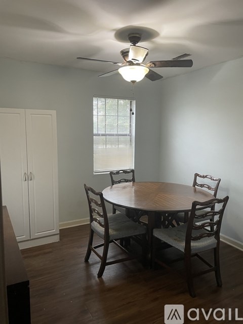 A dining room with a round table and chairs.