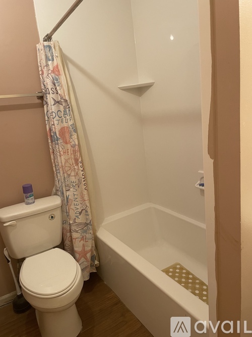 A white toilet sits next to a bathtub in a bathroom.