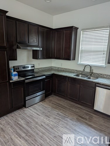 A kitchen with dark wood cabinets and a stove top oven.