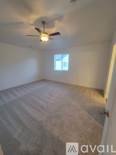 A room with a ceiling fan and a window.