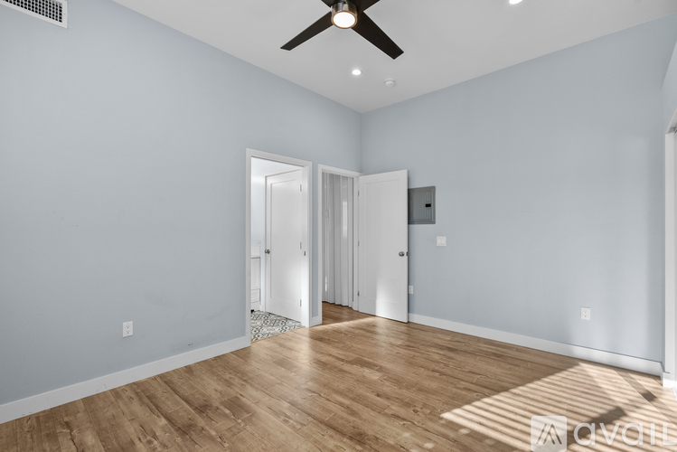 A room with a ceiling fan and two doors.