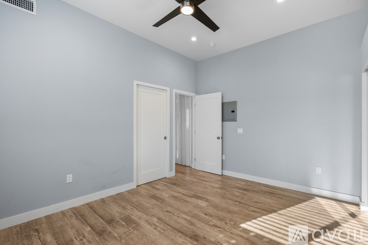 A room with a ceiling fan and two doors.