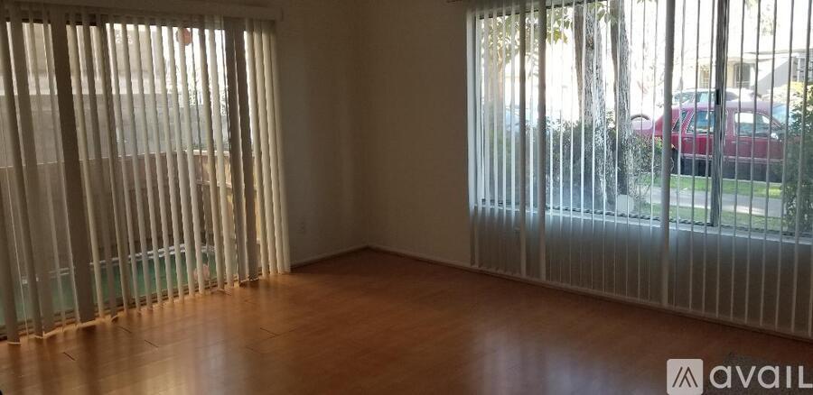 A room with a window covered by vertical blinds.