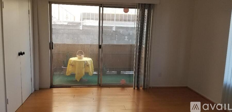 A room with a table and chairs in front of a glass door.