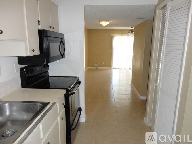 A kitchen with black appliances and white cabinets.