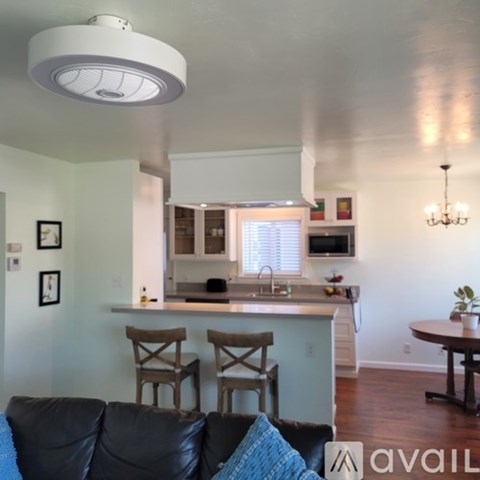 A living room with a couch and a kitchen in the background.