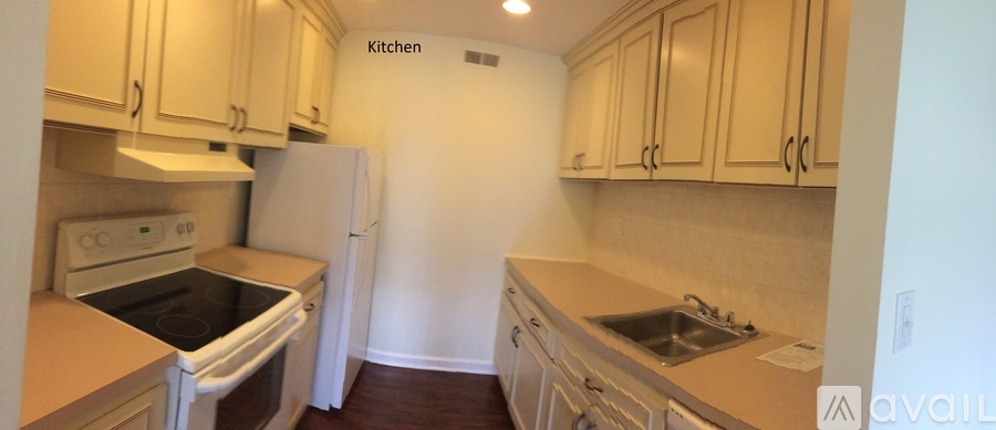 A kitchen with a white refrigerator and wooden cabinets.