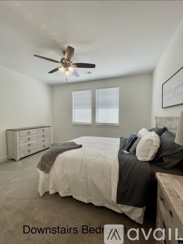 A bedroom with a bed, dresser, and ceiling fan.