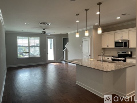 A spacious kitchen with a granite countertop and a ceiling fan.