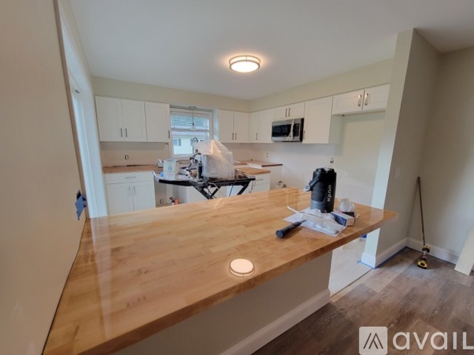 A kitchen with a wooden countertop and white cabinets.