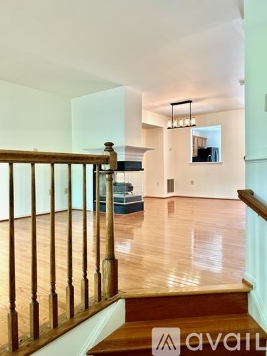 A wooden staircase leads to a living room with a couch and a television.
