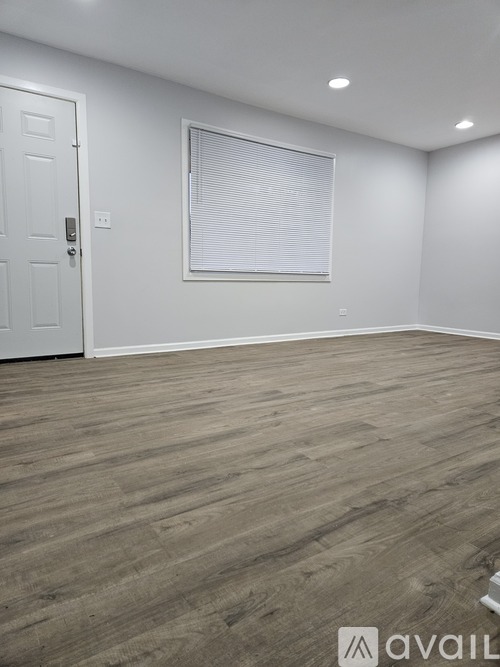 A room with a door and a window with blinds.