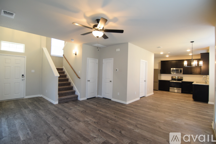 A spacious living room with a staircase leading to the upper floor.