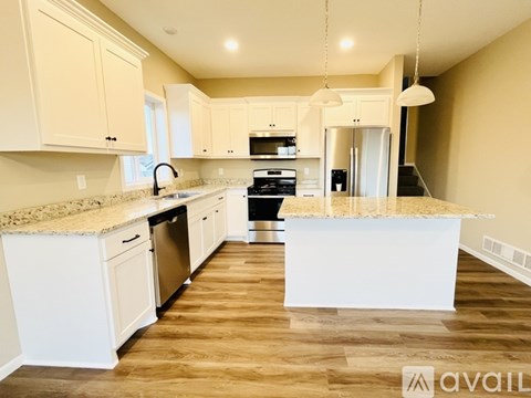 A kitchen with white cabinets and a granite countertop.