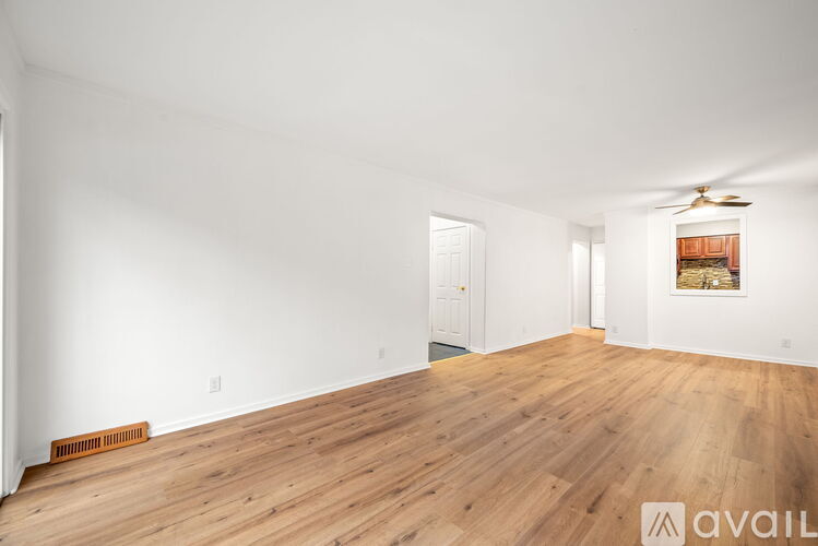A room with wooden floors and a ceiling fan.