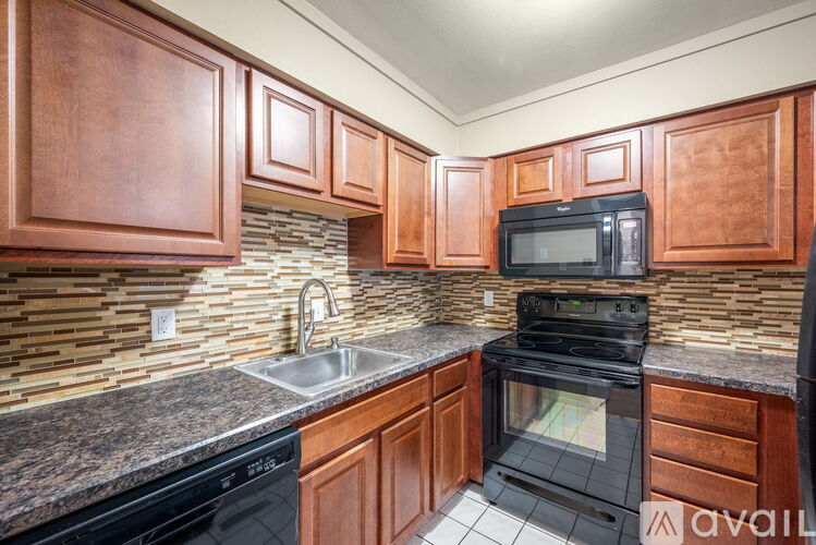 A kitchen with wooden cabinets and black appliances.
