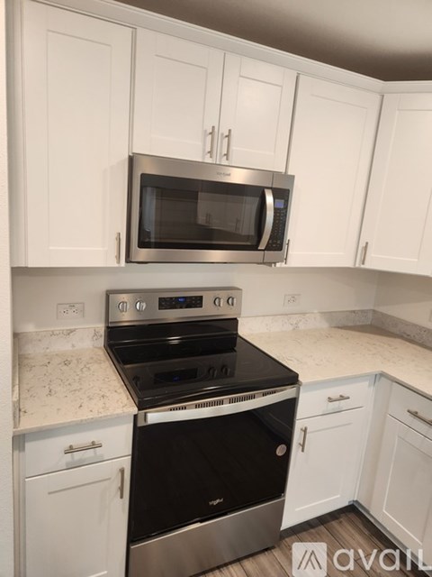 A kitchen with a stainless steel oven and microwave above it.