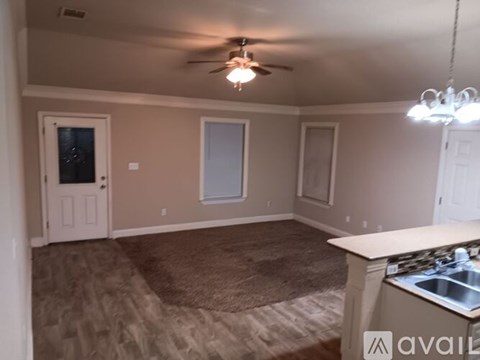 A kitchen area with a fan and a sink.