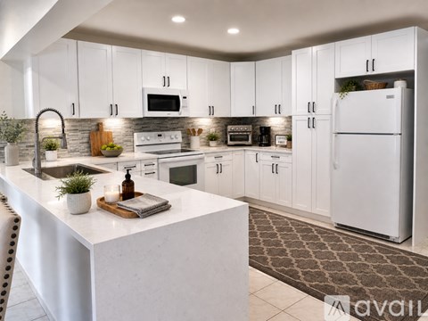 A modern kitchen with white cabinets and appliances.