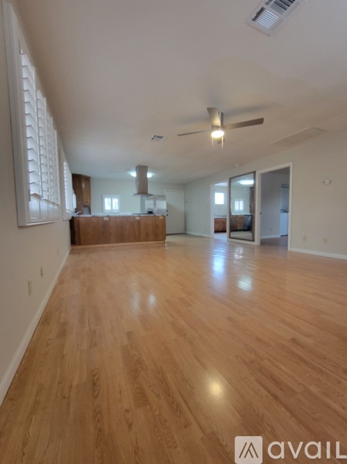A room with wooden flooring and a ceiling fan.