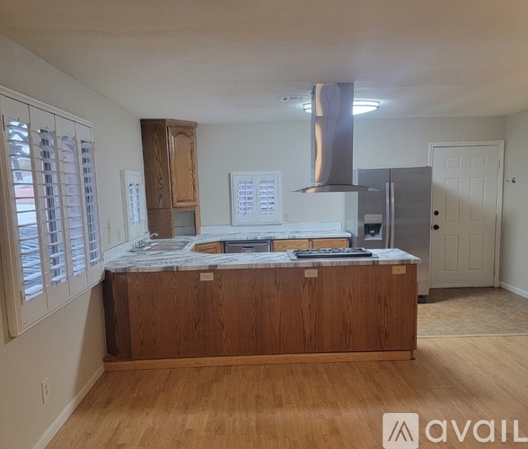 A kitchen with wooden cabinets and a stainless steel range hood.