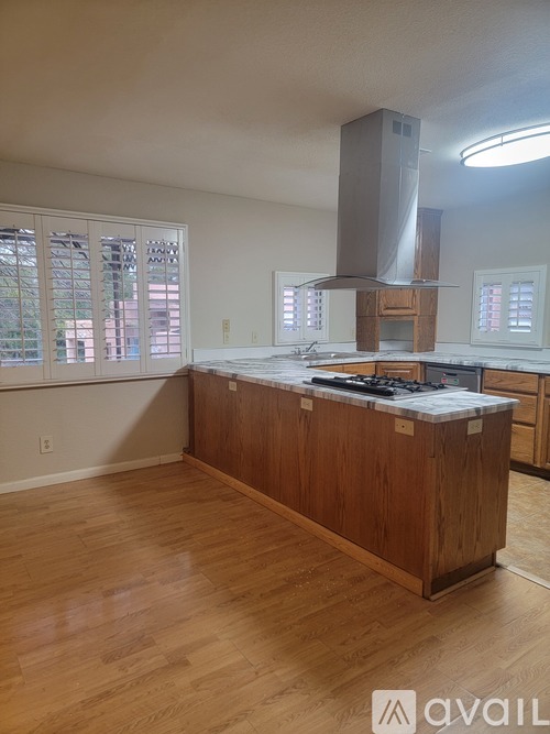 A kitchen with wooden cabinets and a stainless steel range hood.