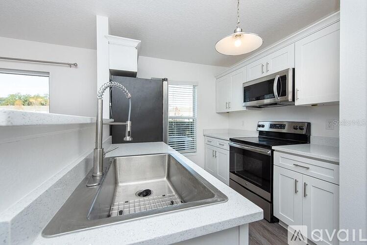 A kitchen with a sink and a microwave.