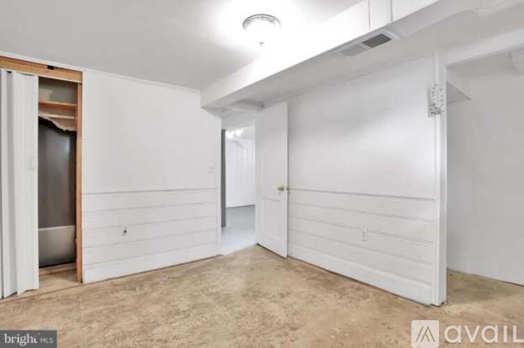 A spacious, empty room with white walls and a door on the right.