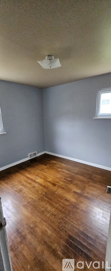 A room with wooden flooring and a window.