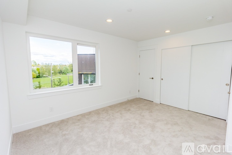 A room with white walls and carpeted floor is available for rent.