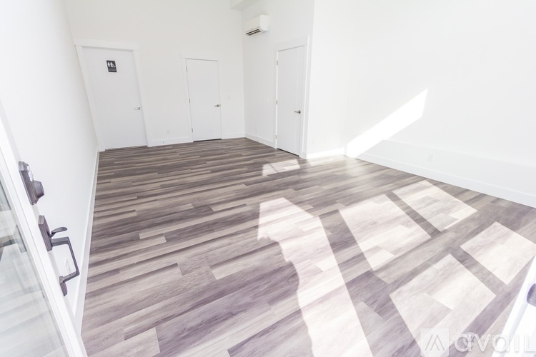 A room with a wooden floor and white walls.
