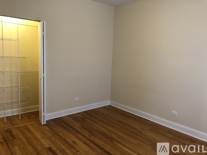 A room with wooden flooring and a white door.