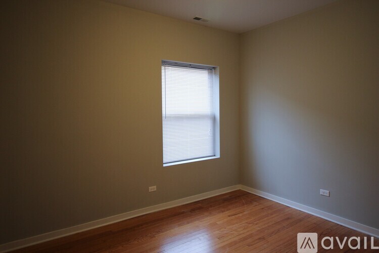 A room with a window and wooden flooring.