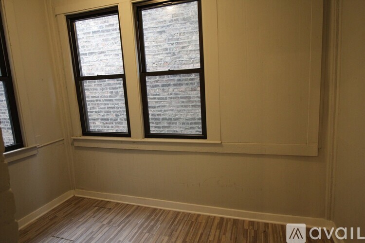 A room with two windows and wooden flooring.