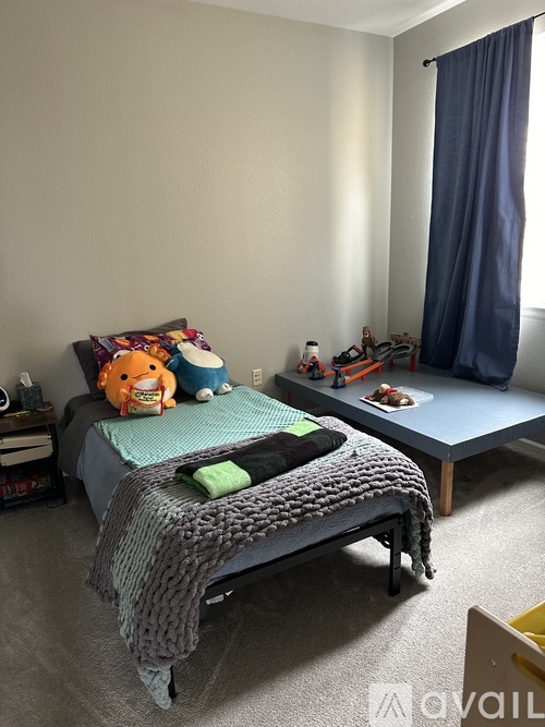 A bedroom with a bed and a small table with items on it.