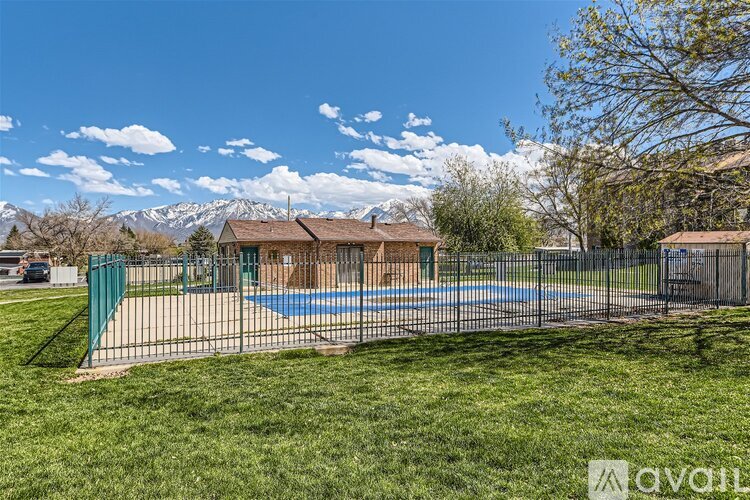 A pool surrounded by a fence in a grassy area.