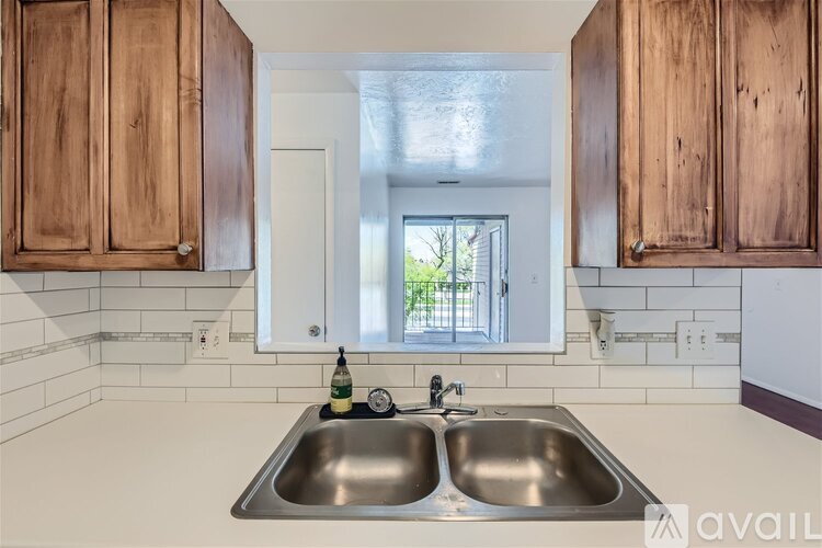 A kitchen with wooden cabinets and a stainless steel sink.