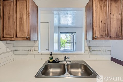 A kitchen with wooden cabinets and a stainless steel sink.