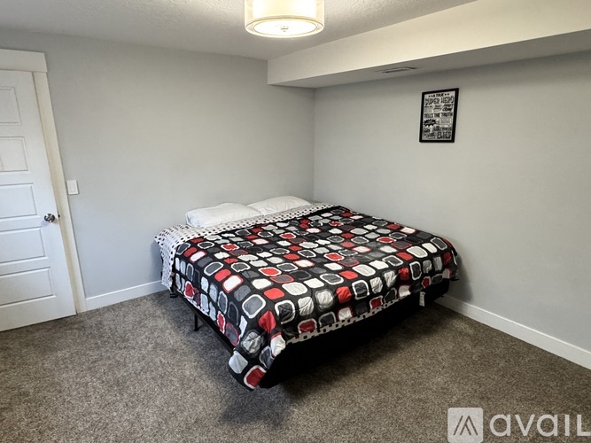 A bedroom with a bed and a poster on the wall.