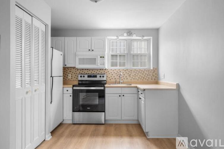 A kitchen with white cabinets and a black oven.
